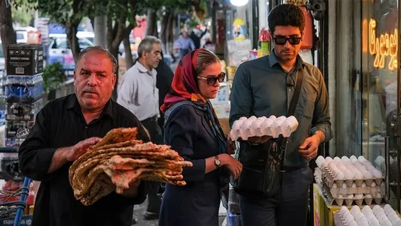 File photo of people shopping for eggs and bread at a street market in Iran amid rising food prices.