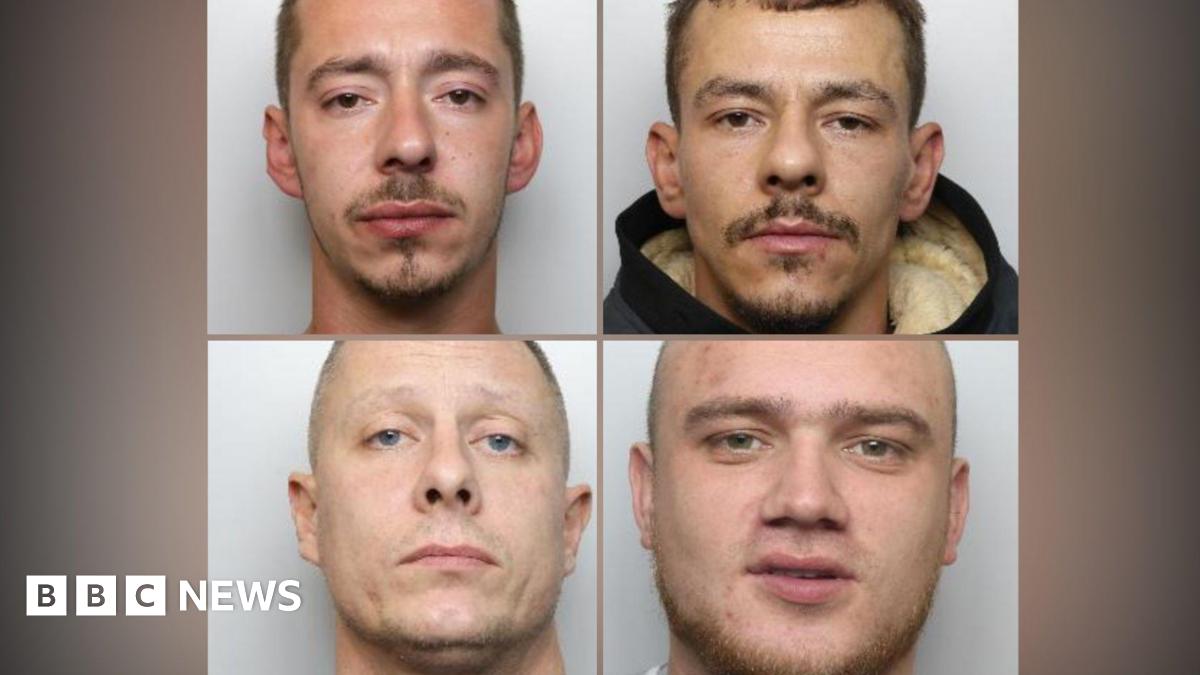 Police mugshots of four men. On the top left is a man with sunken brown eyes and stubble. On the top right is a man with brown eyes, stubble and a black hooded coat. On the bottom left is man of around 40 with blue eyes. On the bottom right is a man with no hair and stubble. All four are staring directly into the camera.
