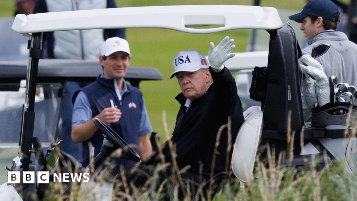 Donald Trump waves to onlookers from his golf buggy