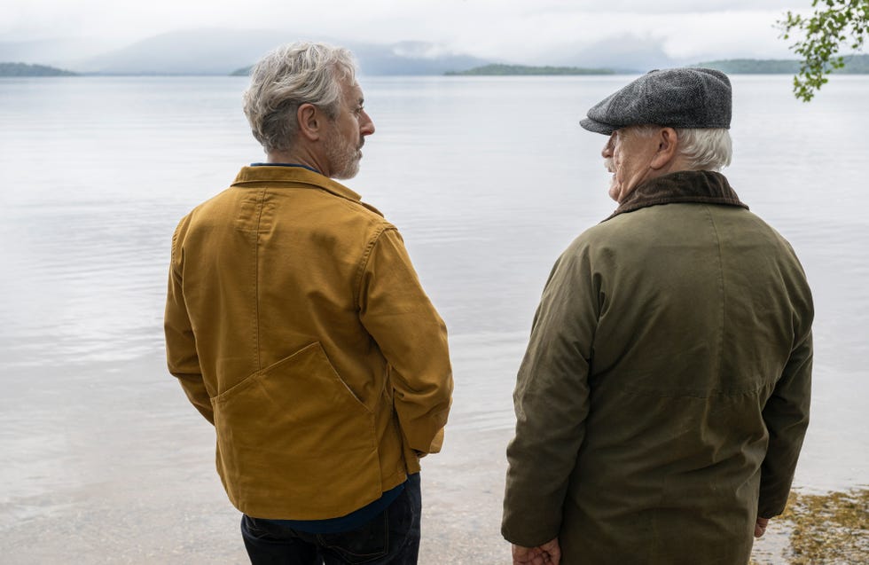 two individuals standing by the waters edge facing away