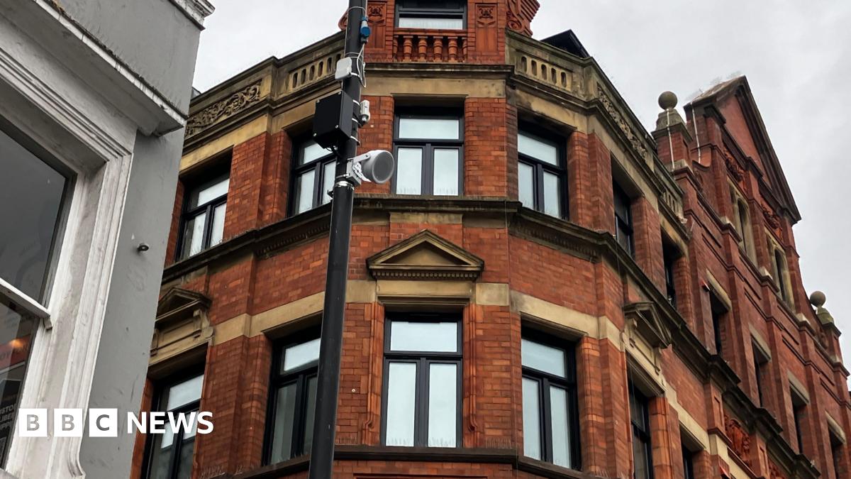 Image shows Laura Macmillan, a classically trained musician. She is holding a violin in each hand. Laura is wearing a black dress and has long blonde hair.