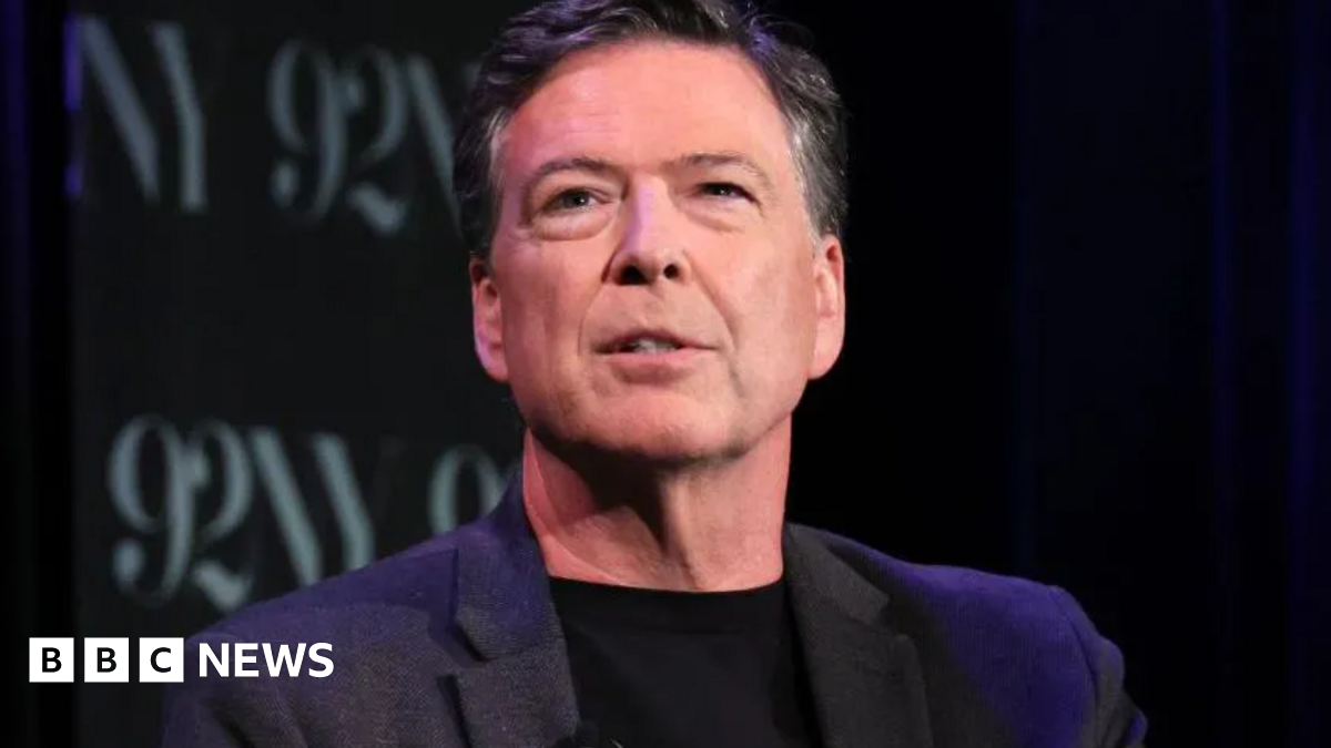 Former FBI director James Comey wearing a dark suit, with a dark background