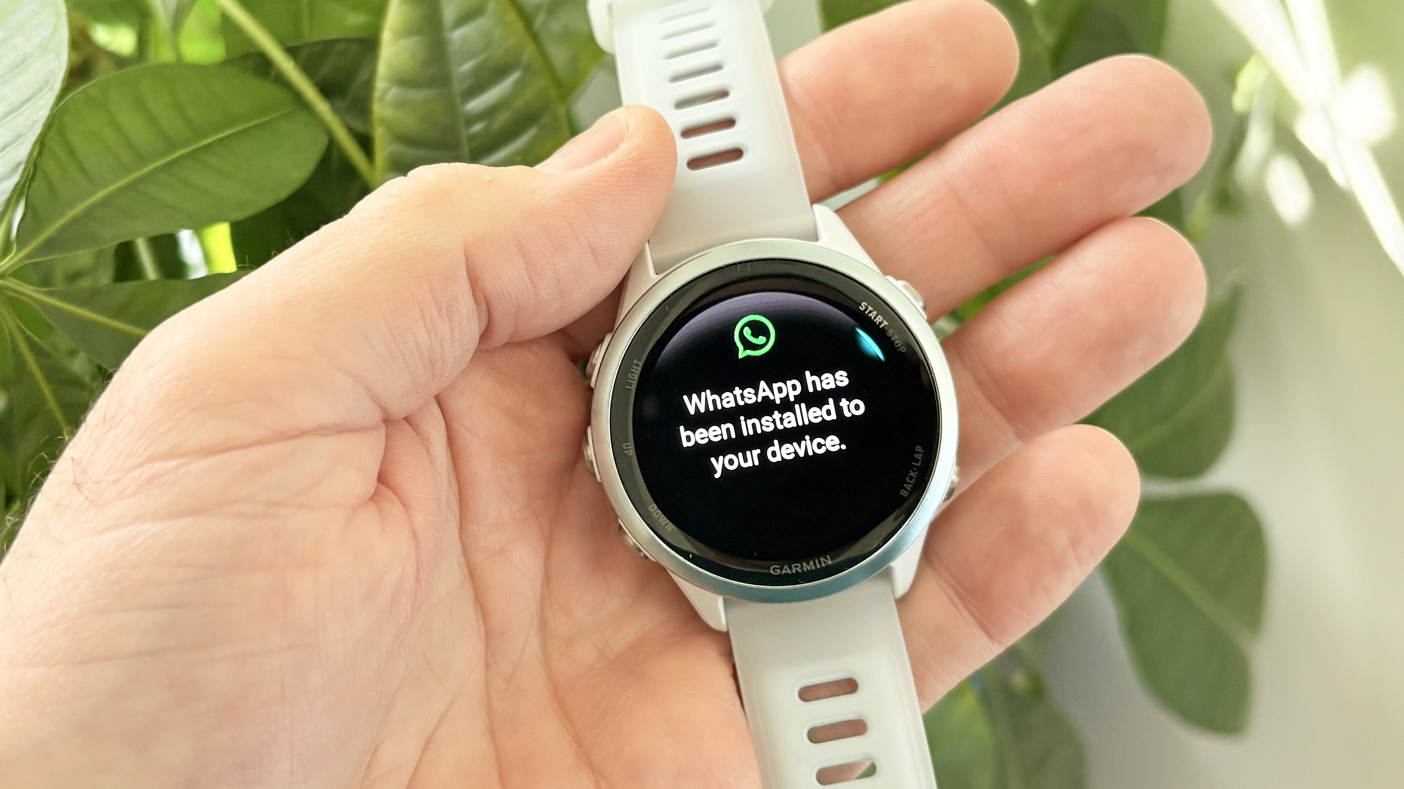 Garmin Forerunner 570 with WhatsApp shown on the screen
