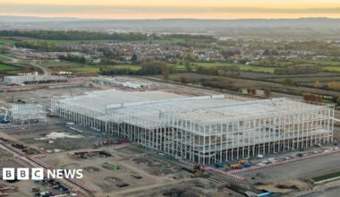 an aerial view of the construction site showing vehicles and concrete piles driven into the ground