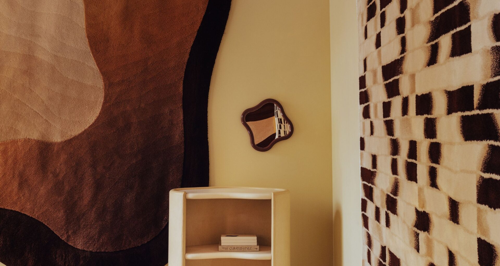 a showroom with neutral rugs on the wall, curvy furniture, and a mirrored and carpeted floor