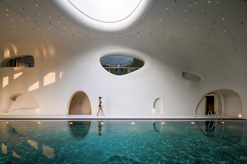 wutopia lab carves soft white caving interiors for pebble-shaped mountain hotel in china - 5
