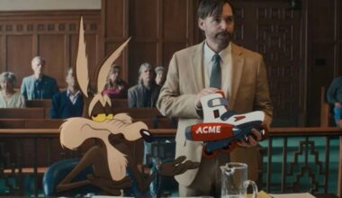 animated Wile E. Coyote seated in a courtroom while his lawyer holds up an Acme product