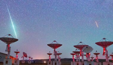 Shooting stars are pictured streaking towards a collection of radar dishes pointing towards the starry night sky.
