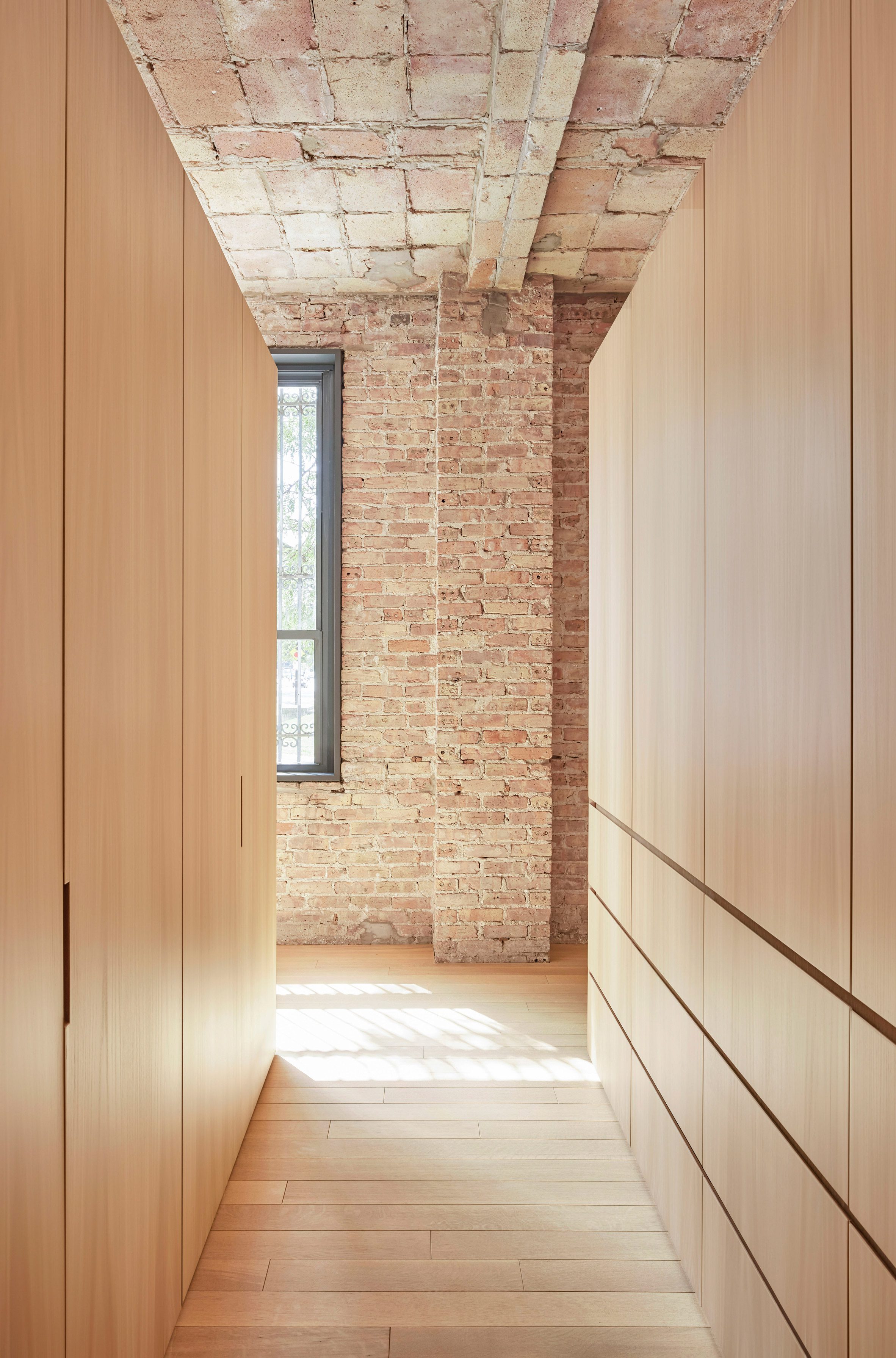 White oak closets create a walk-in space in between
