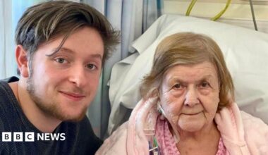 Tristan Essex on the left next to Jessie Stockdale who is in a hospital bed wearing a pink dressing gown.