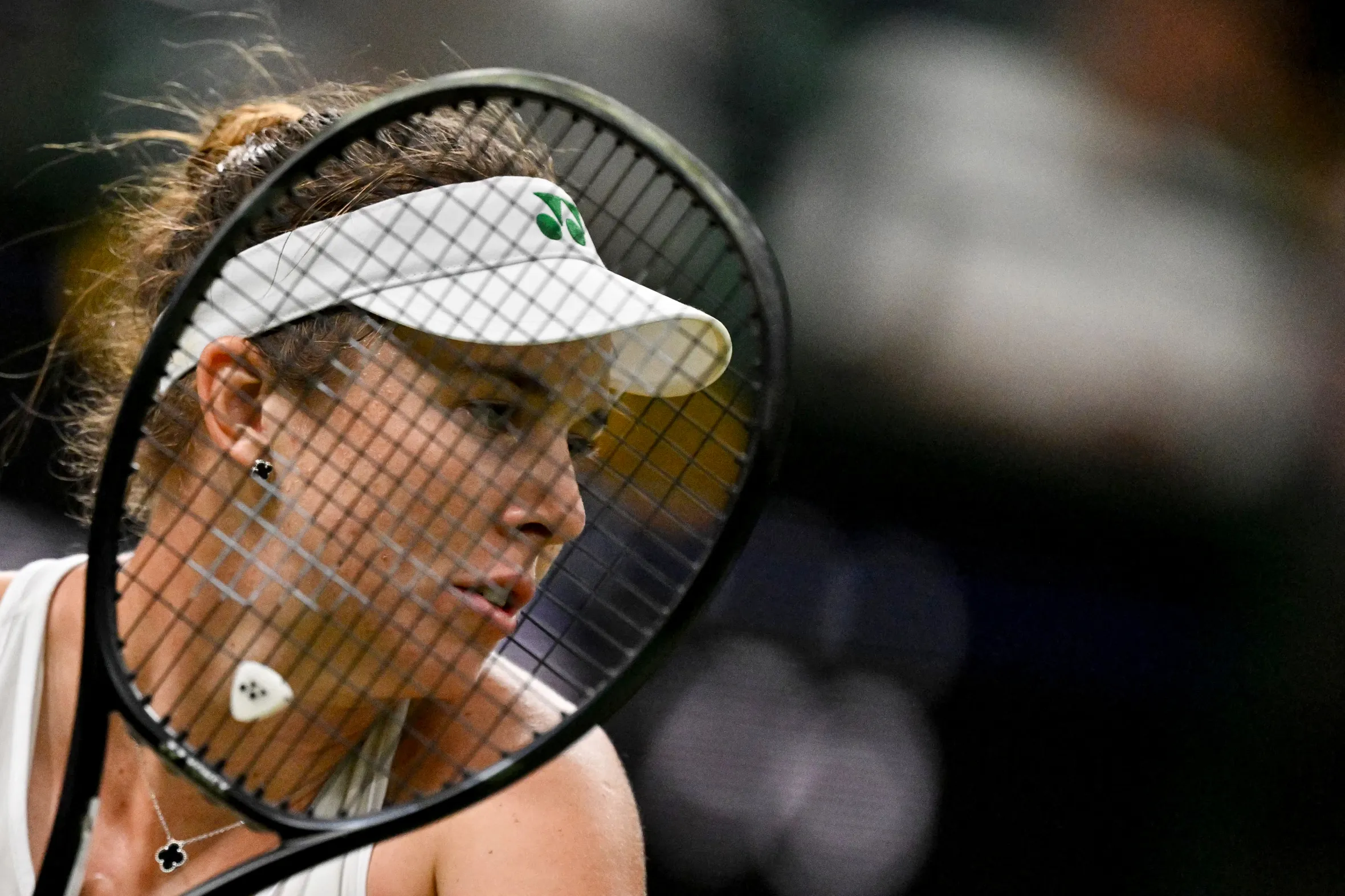 Linda Noskova looking intently while holding a tennis racket.