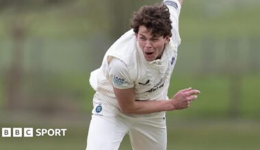 Henry Brookes crouched forward with his right arm held up in the air behind him after he bowls a ball during a friendly for Middlesex