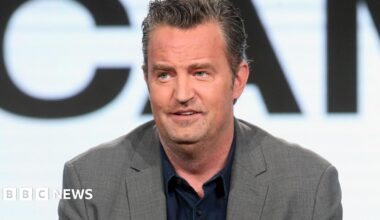 Actor Matthew Perry, wearing a grey suit jacket, speaking onstage at the 2017 Winter Television Critics Association Press Tour in Pasadena, California