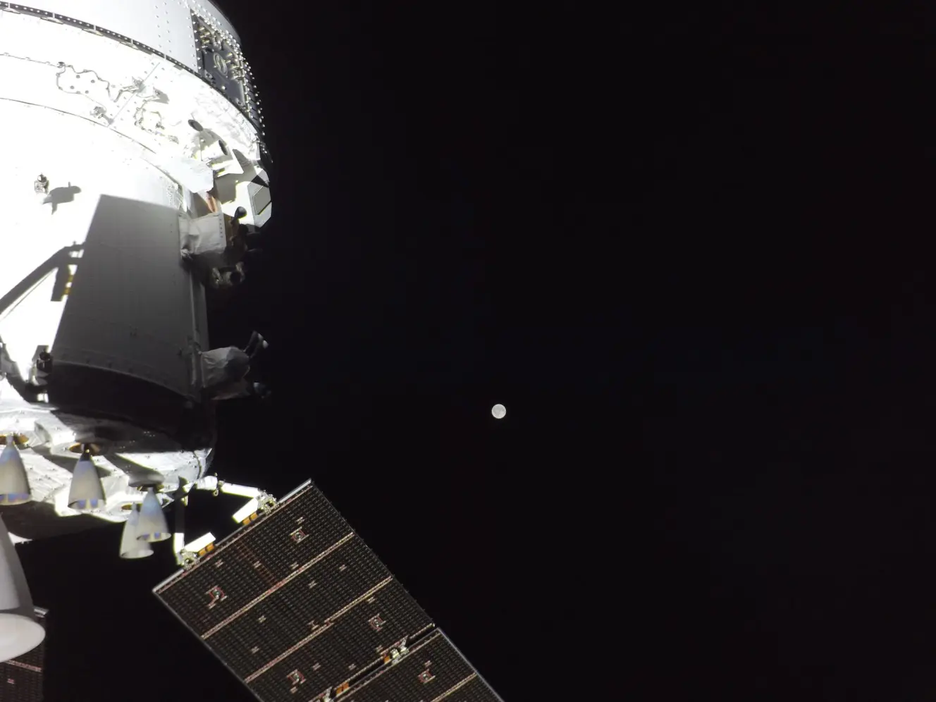 The Orion spacecraft with the Moon in the distance, as captured by a camera on the tip of one of its solar array wings.
