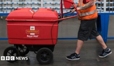 A worker pushes a trolley at the Royal Mail sorting office on Penarth Road on May 15, 2017 in Cardiff, United Kingdom