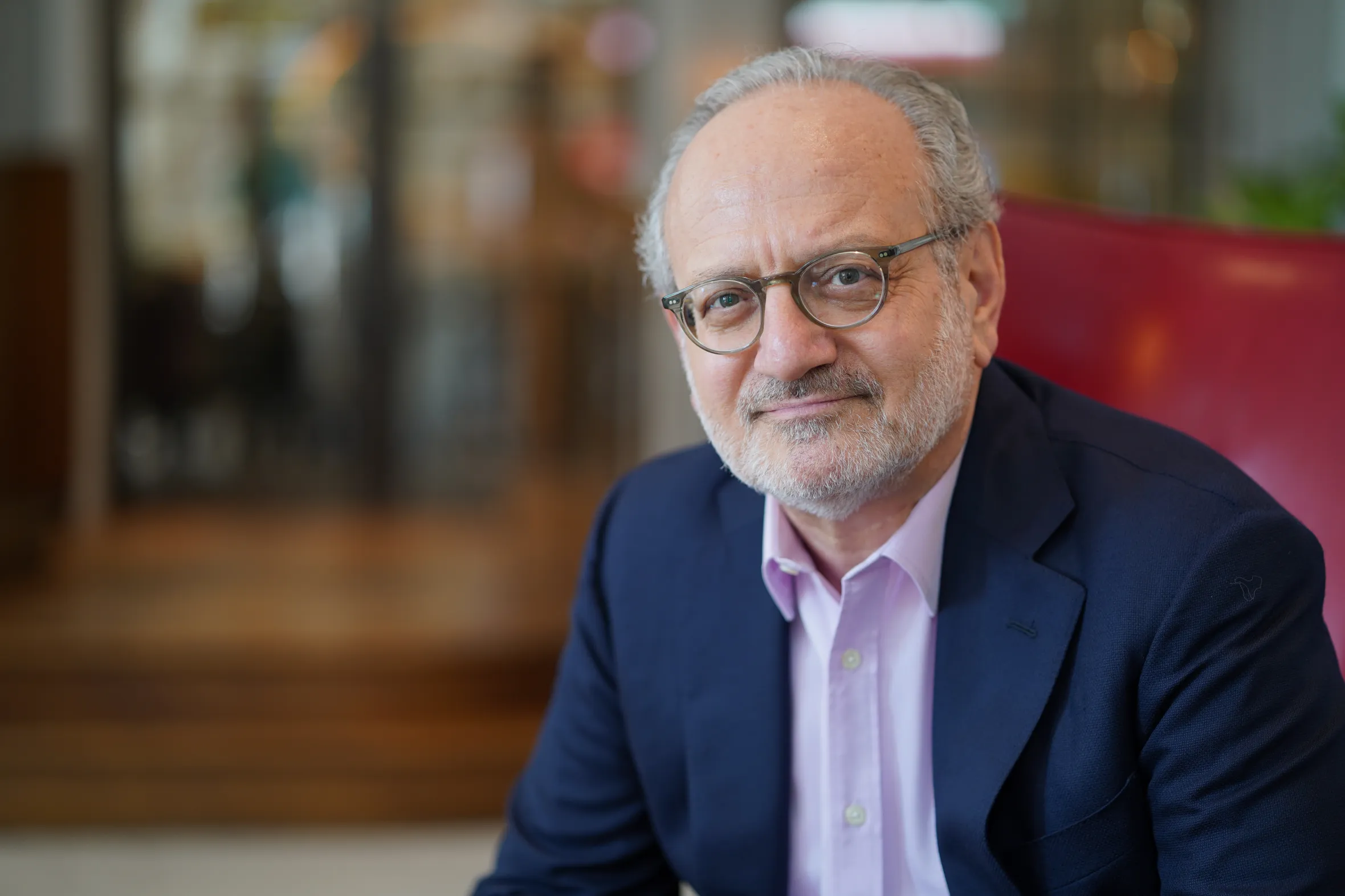 George Jerjian, a man with glasses and a beard, smiles at the camera.