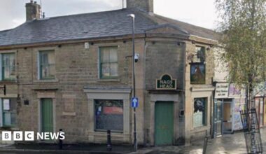 Street view image of the Nag's Head pub. A stone building on a street corner with green windows and doors and a sign in black with gold wording over the door, which is on the corner, that says NAG'S HEAD