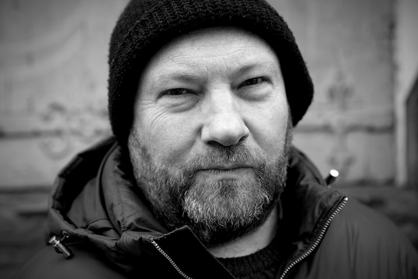 A man in a puffer jacket with a beanie.