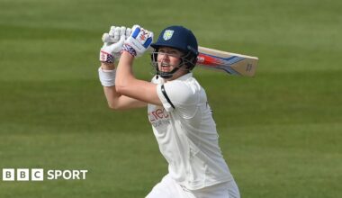 Ben McKinney looking upwards with his bat over his left shoulder