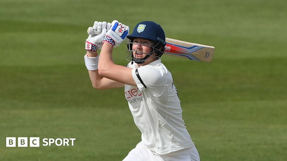 Ben McKinney looking upwards with his bat over his left shoulder