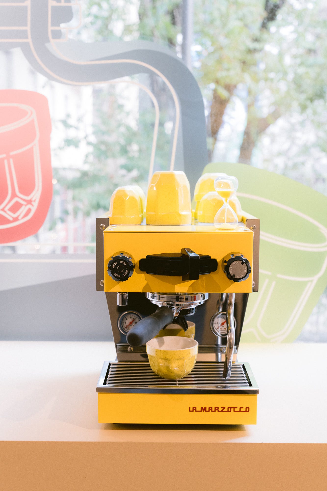 bright yellow espresso machine with cups