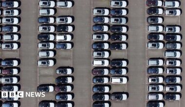 An aerial view of whit and black imported new cars on the quayside of Alexandra Dock at Grimsby Port.