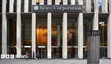 Exterior image of an office building with the words "News Corportation" on it, some people are in the foreground of the image walking.