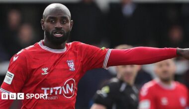 Hiram Boateng in action for York City with his left arm raised and pointing
