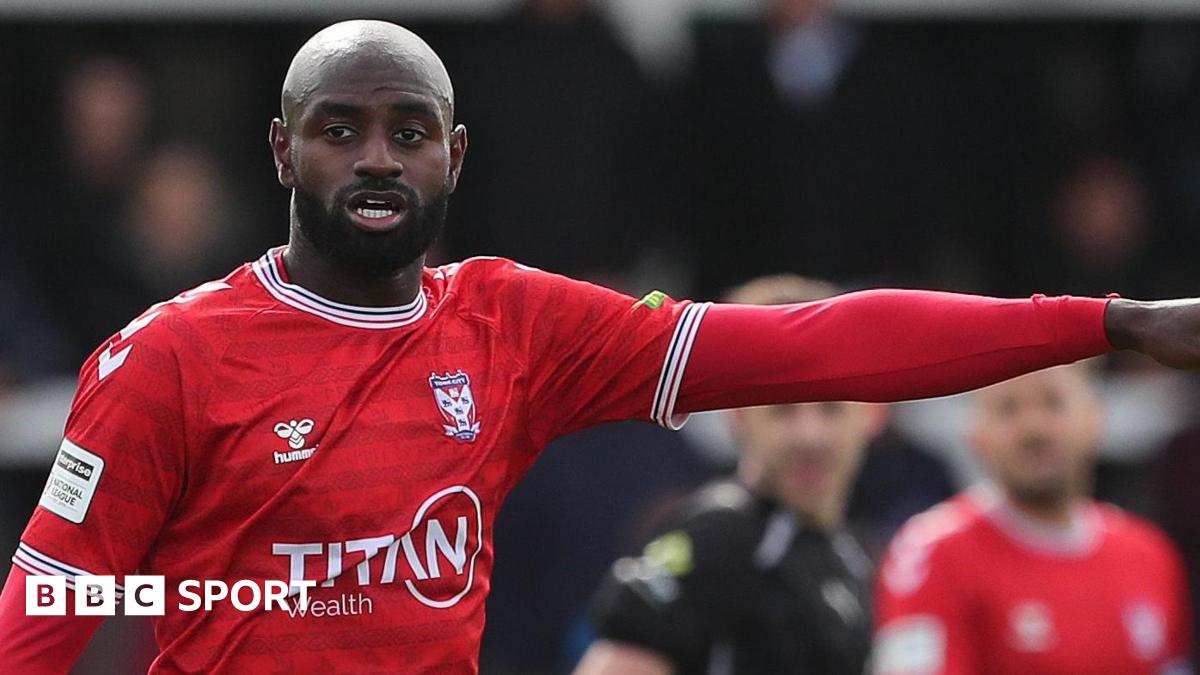 Hiram Boateng in action for York City with his left arm raised and pointing