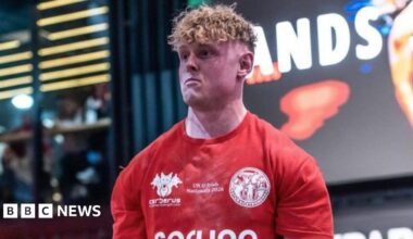 Jake Orr, a man with blonde curly hair, is pictured in a red sports top.