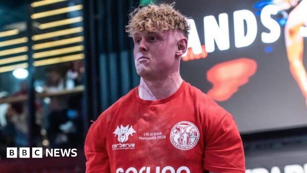 Jake Orr, a man with blonde curly hair, is pictured in a red sports top.