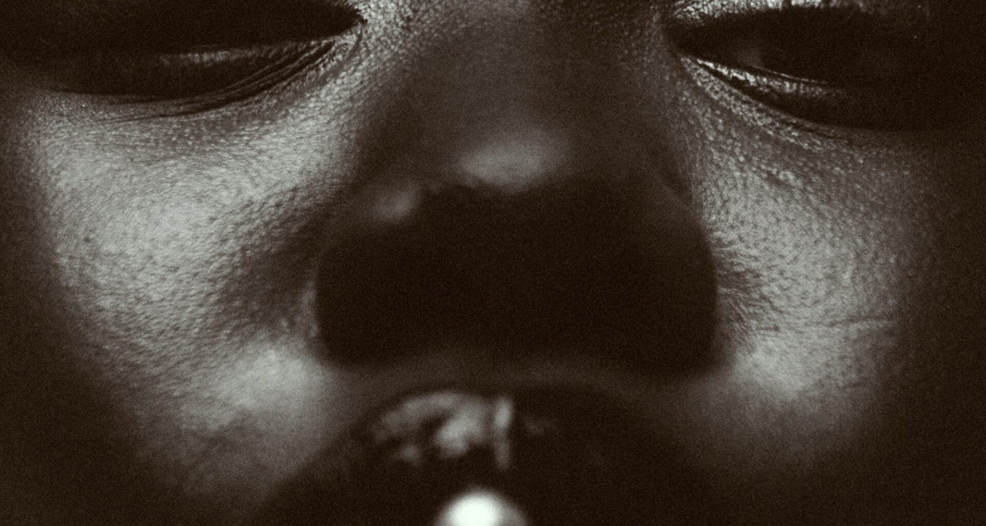 a black and white photo by Austn Fischer of a woman with a pearl in her mouth