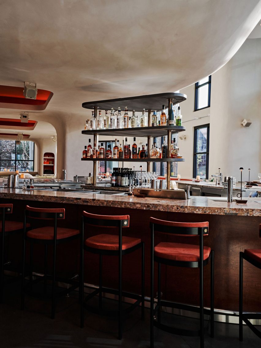 A curved central bar clad in Ceppo Rosso marble