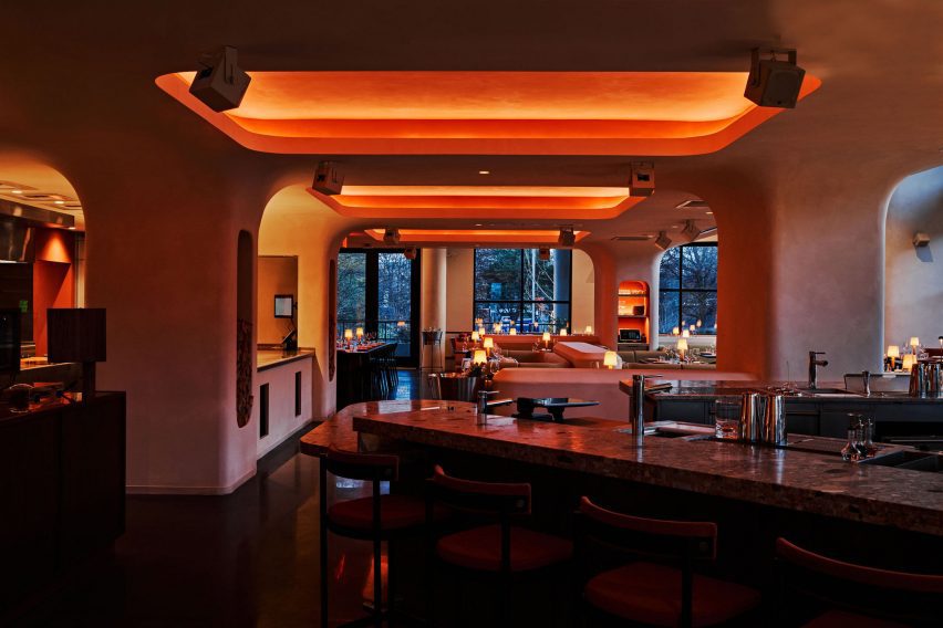 Niches carved into the ceiling and walls of a restaurant glow at night