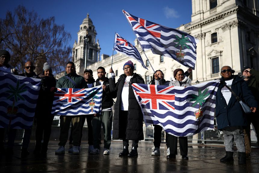 Supporters and members of the Chagos Islands hold placards and flags outside the Houses of Parliament in January to protest against the proposed deal.