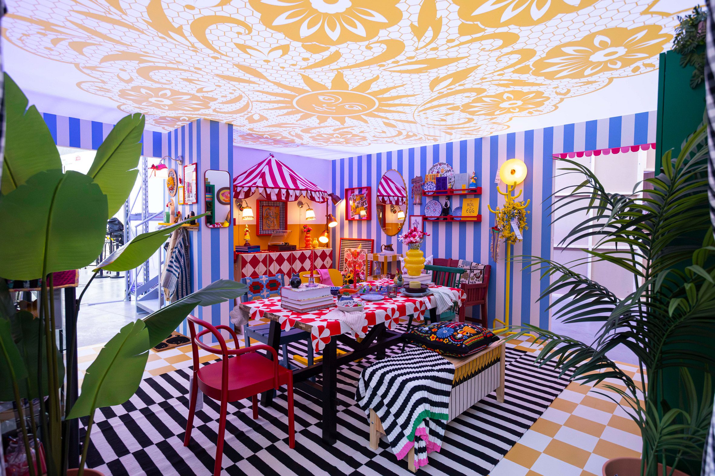 A colourful dining room with striped walls, patterned textiles and a decorated table