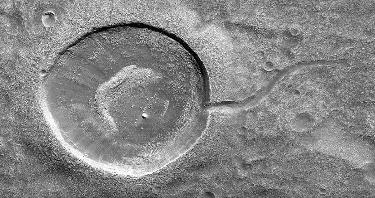 A tadpole crater on Mars, formed by water that filled an impact crater breaking out and carving a valley. Image by the Mars Reconnaissance Orbiter. Credit: NASA/JPL-Caltech/Univ. of Arizona