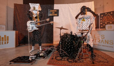 Canadian band Angine de Poitrine stand side by side in polka dotted costumes and papier mache headwear.
