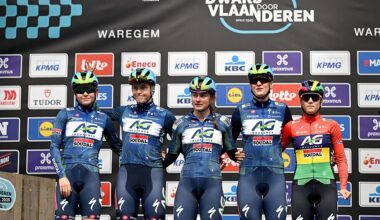 A shot of five AG Insurance-Soudal riders standing on the stage, side by side, at the sign on presentation before Dwars door Vlaanderen 2026