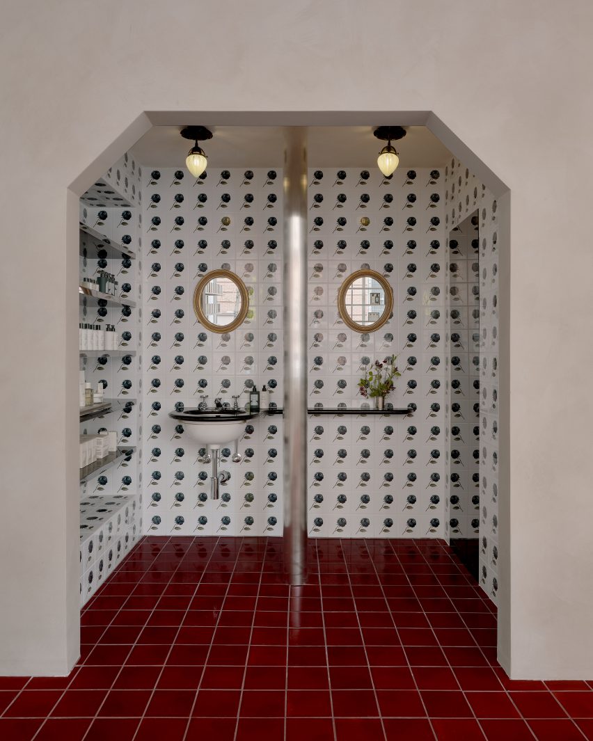 Tiles emblazoned with a black rose motif line a niche for testing perfume products