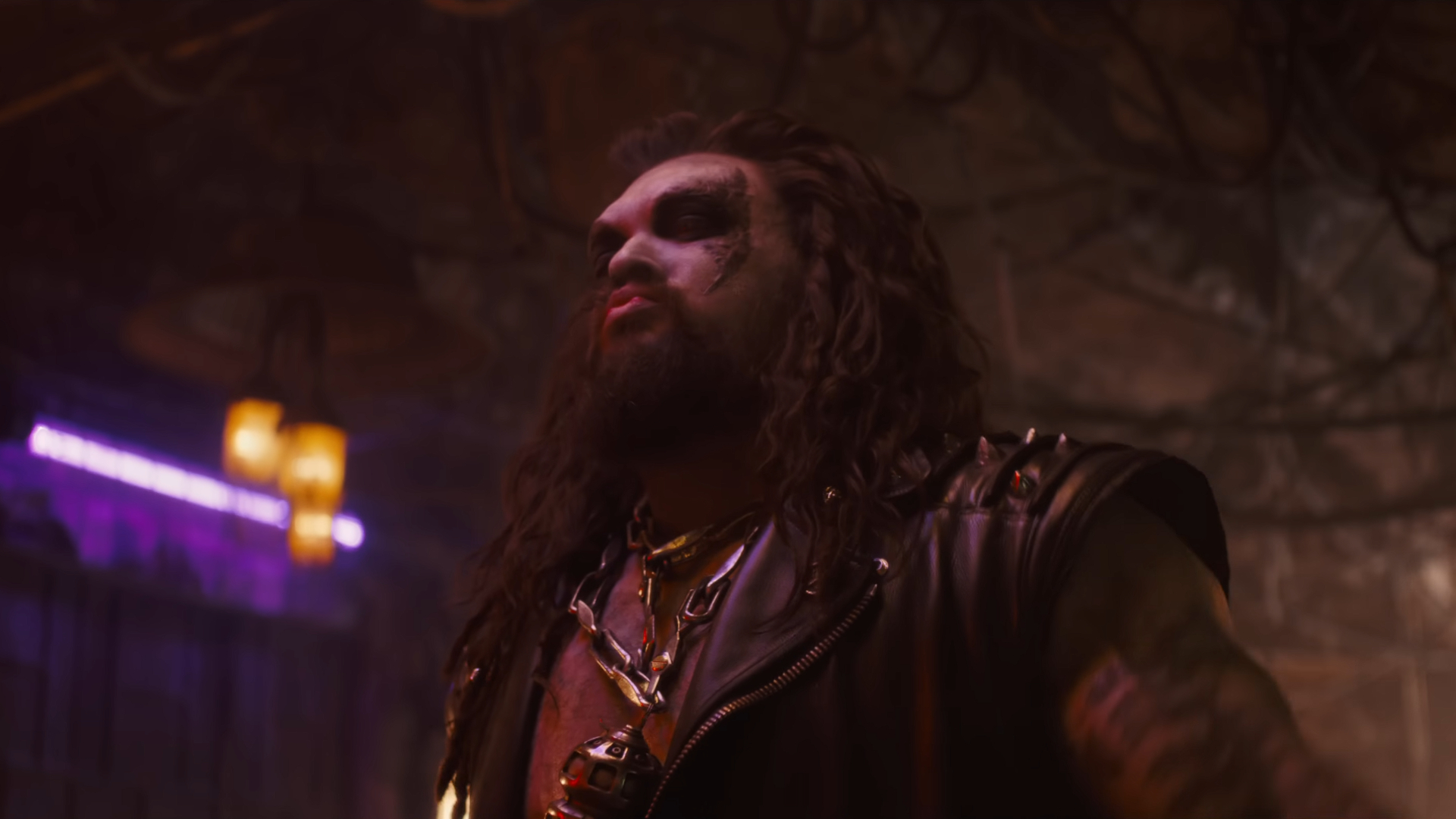 A man with long dark hair and face make-up in a sci-fi bar