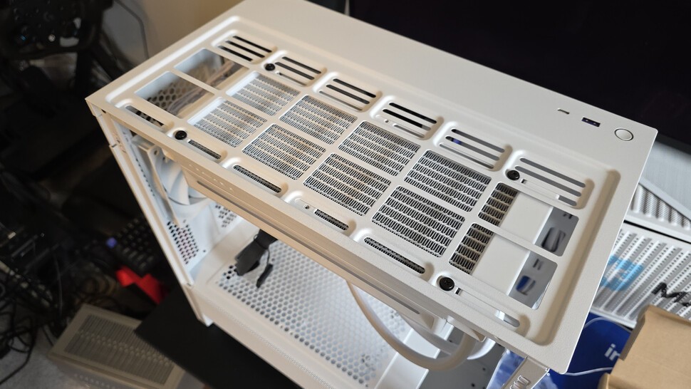 Our AiO is going on the top of the case, so the fans are screwed into the radiator with four long screws, then the radiator is screwed into the top of the case with short screws. A dust filter will hide the screws from view.