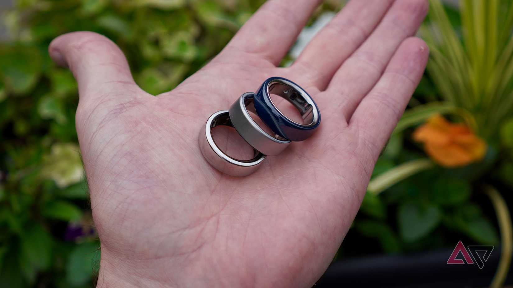 A person holding the Oura Ring 4, Oura Ring Gen 3, and Oura Ring 4 Ceramic