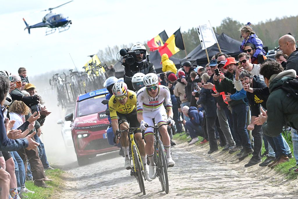 UAE Team Emirates-XRG's Slovenian rider Tadej Pogacar cycles in a breakaway on a cobblestone sector ahead of Team Visma - Lease a Bike's Belgian rider Wout van Aert during Paris-Roubaix