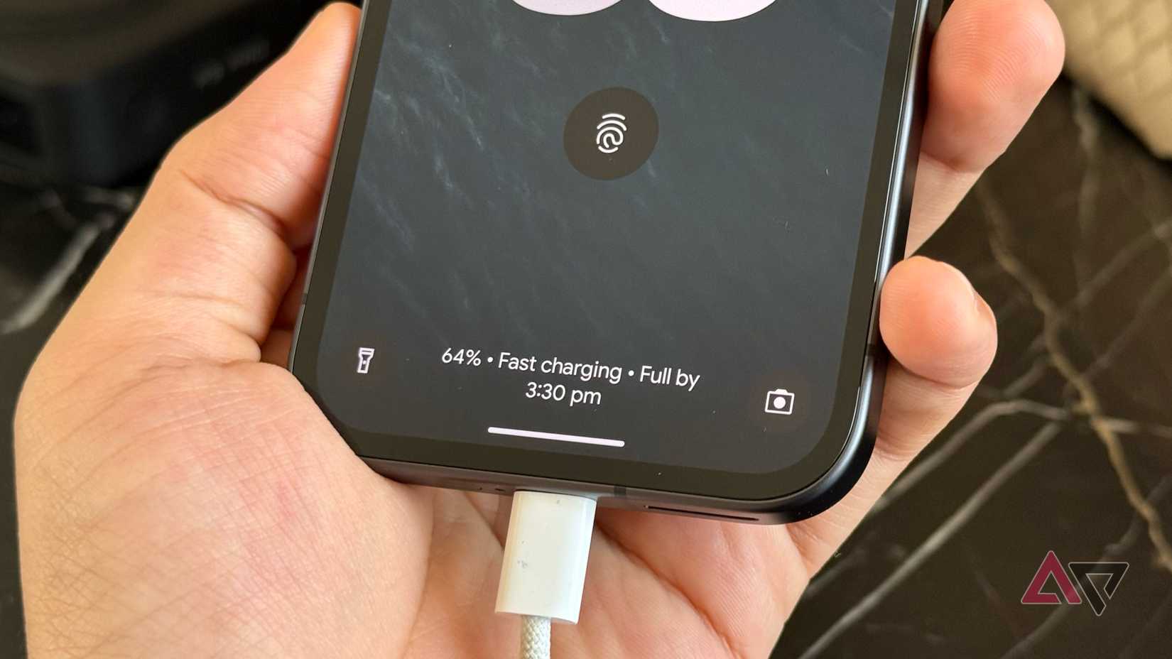 Pixel 9a charging via a USB-C cable showcasing percentage on lock screen