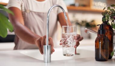 Person pouring water from a faucet into a glass