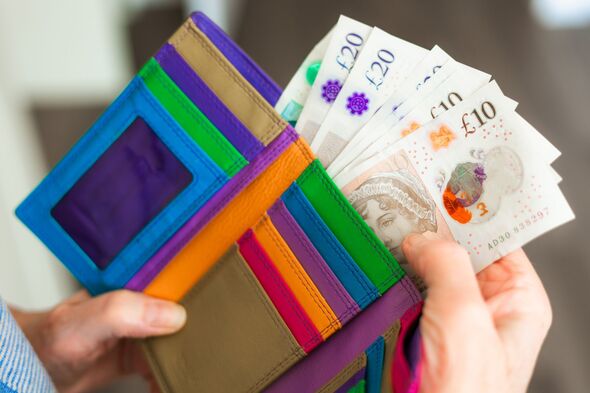 Senior woman taking bank notes from her wallet