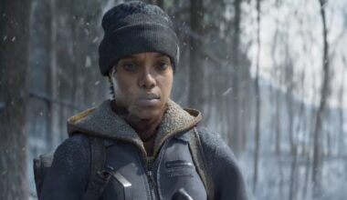 A woman stands in the cold hunting a deer.