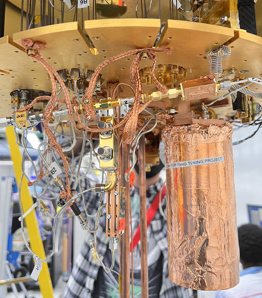 Setup of an experiment at Fermilab to test use of an ultrasensitive detector to search for evidence of dark photons, a hypothetical particle of dark matter. Housed within a dilution refrigerator kept at cryogenic temperatures, the copper wrapped mu-metal can, at right, contains the detector. Credit: Fang Zhao, Fermilab