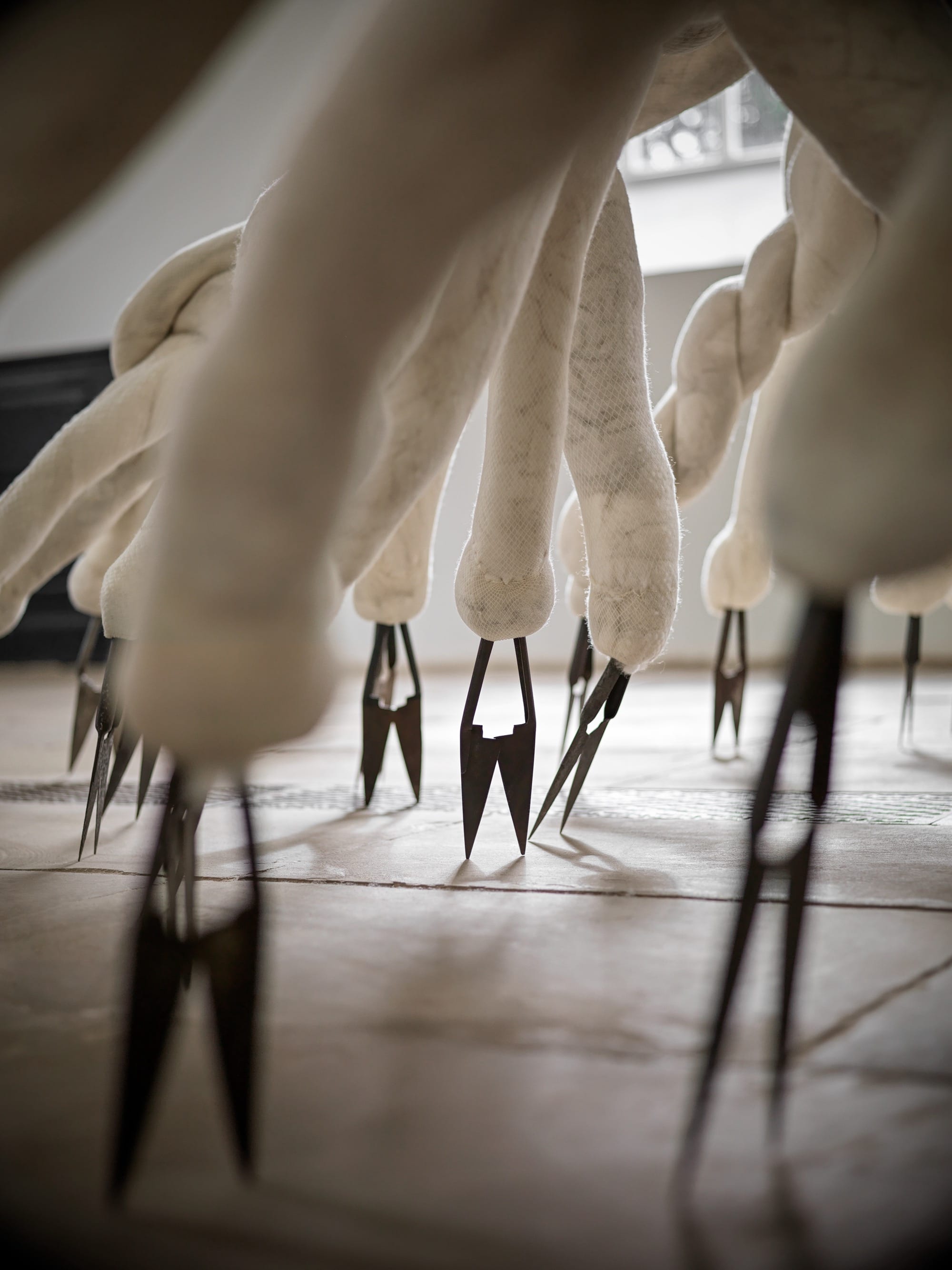 a detail of a large-scale textile installation by Nicola Turner with undulating, twisted details and metal blades for